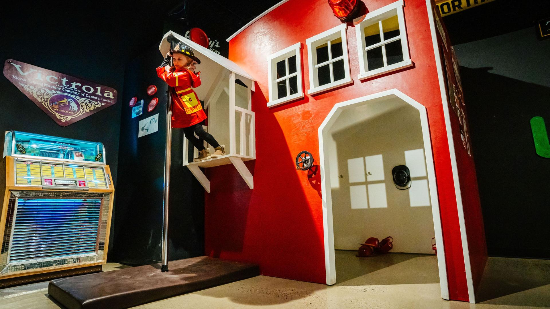 Kid slides down fire pole at The Exploration Place