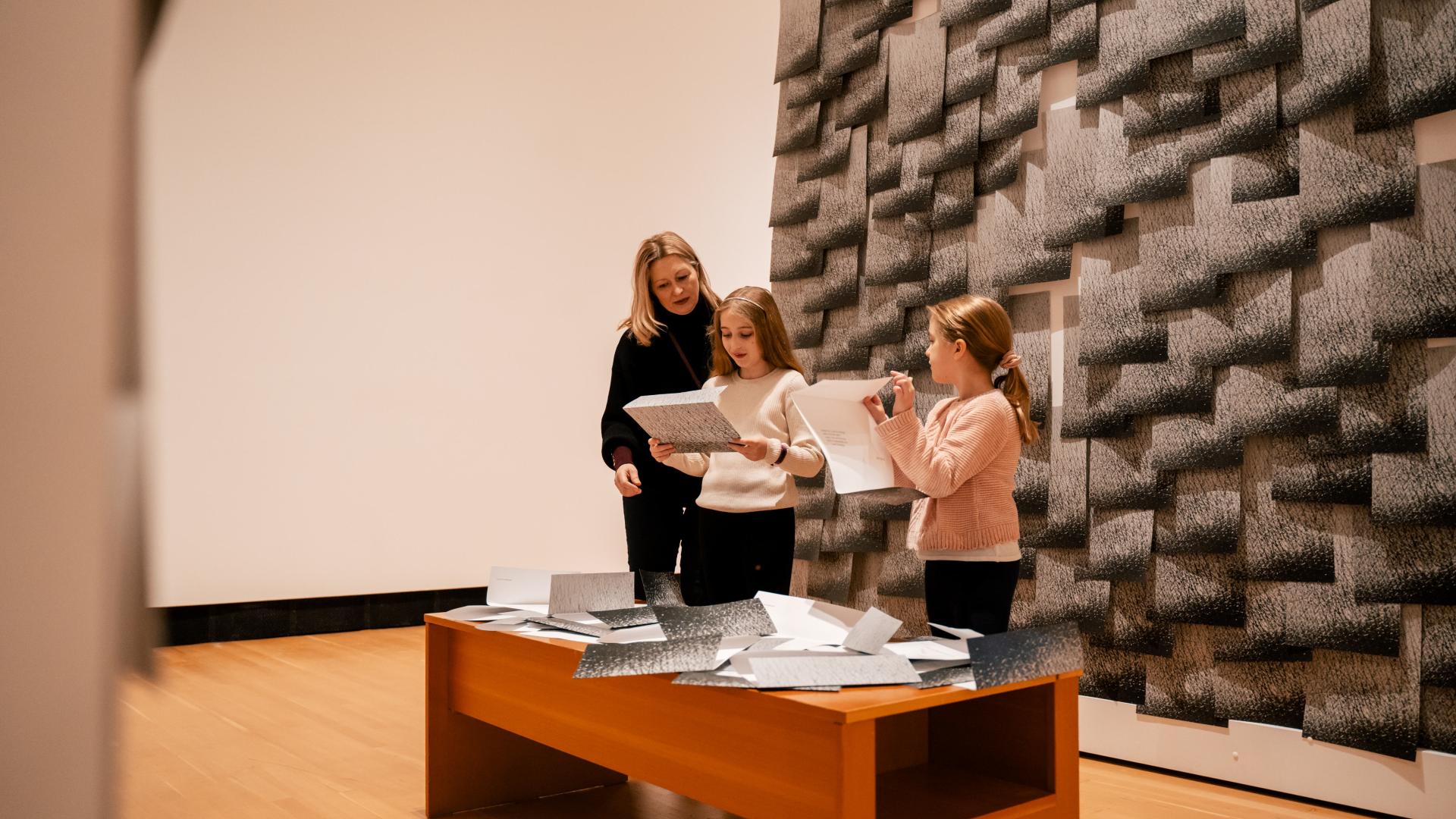 A family inspects art at Two Rivers Gallery 