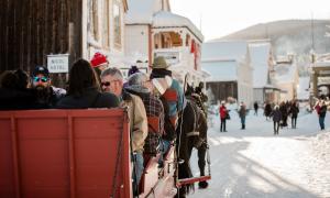 A group of people take a horse-drawn sleigh ride through Barkerville in winter