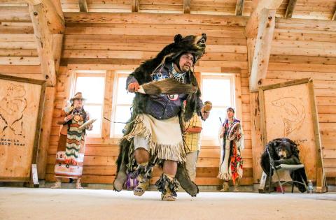 A man in traditional clothing and a bear skin dances at Barkerville's Indigenous People's Day